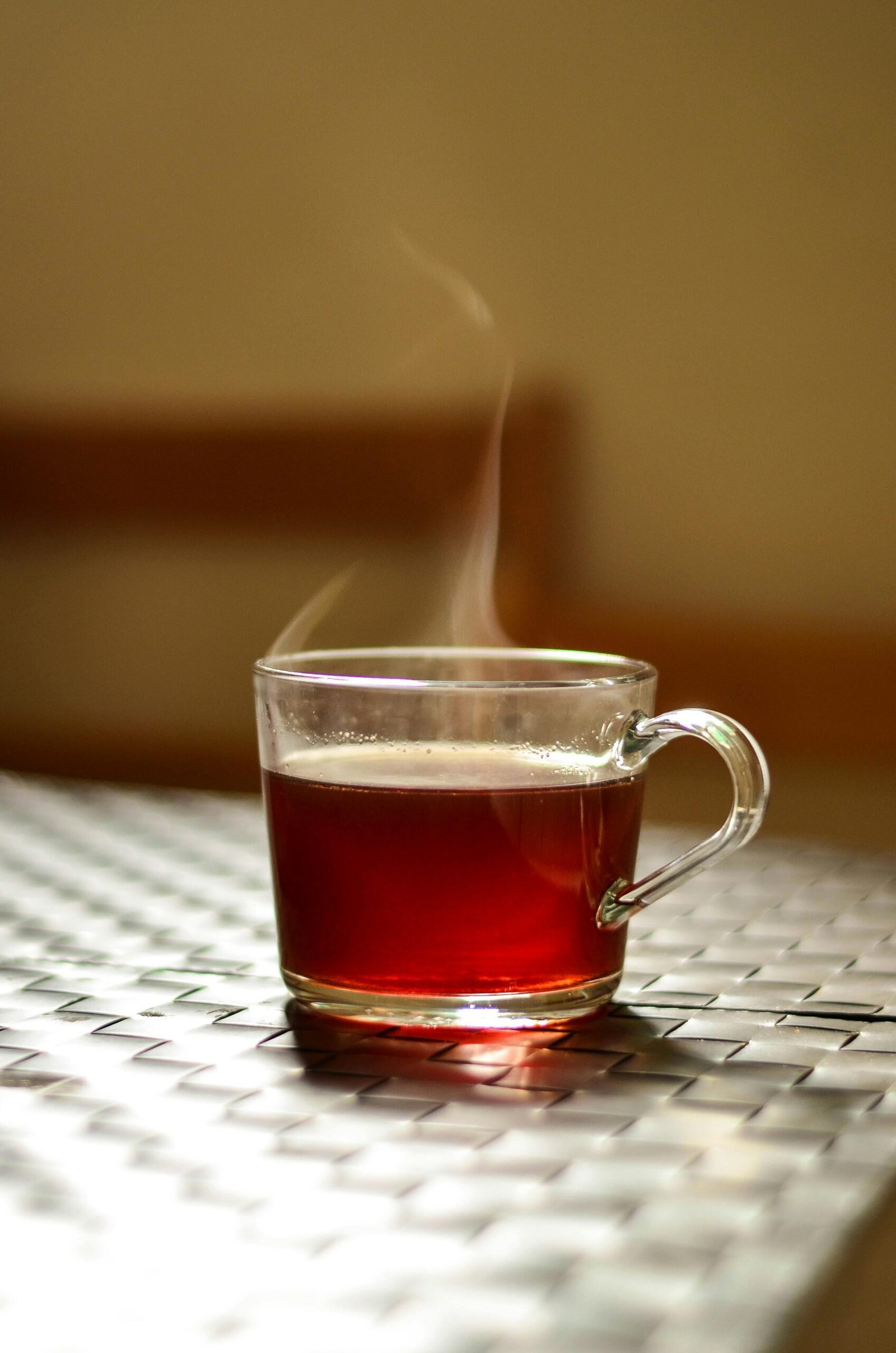 pexels photo 905485 905485 A steaming glass of tea adds warmth to an indoor setting, captured in a modern style.
